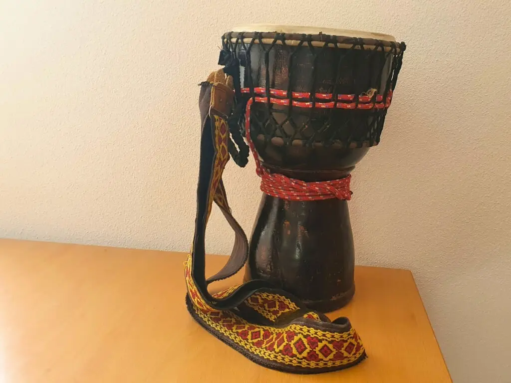 Tradičný drevený africký bubon djembe na stole.