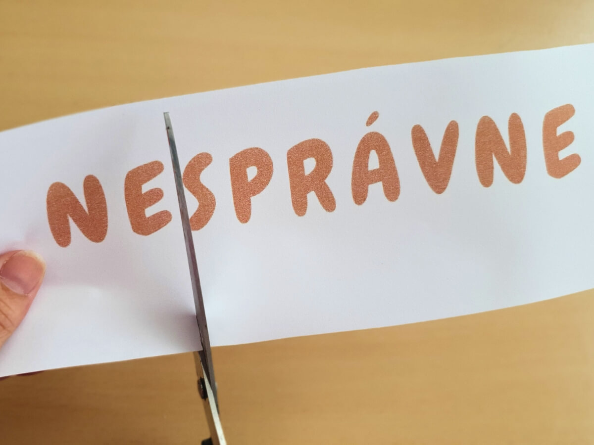 Nápis s textom nesprávne a nožnice.